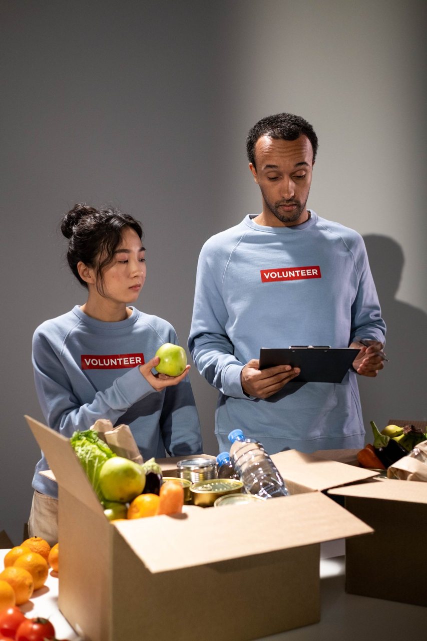 Free Volunteers organize donations, showcasing community teamwork in action. Stock Photo